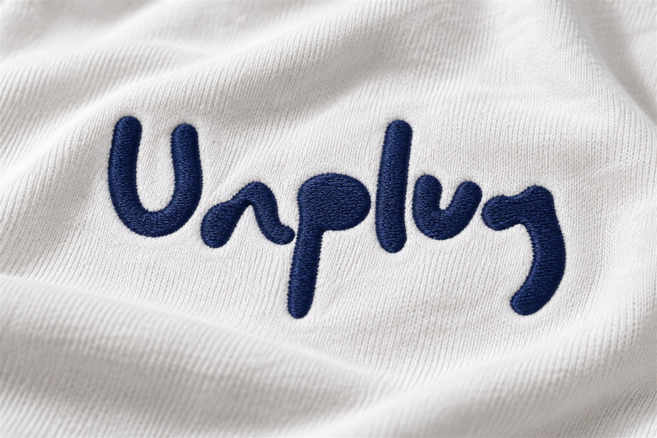 Logo Unplug ricamato in blu su cotone chiaro.