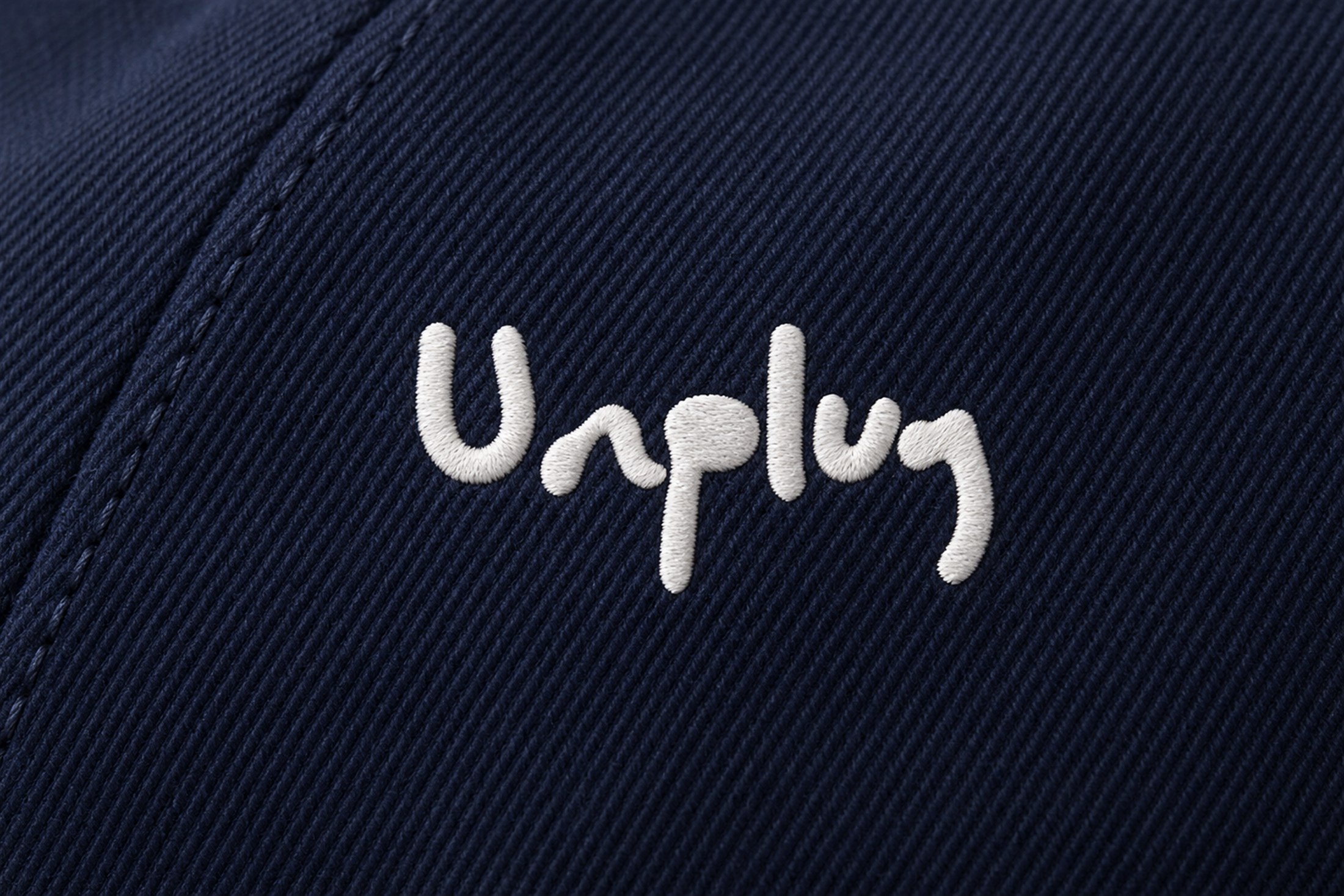 Ricamo bianco Unplug su twill blu.